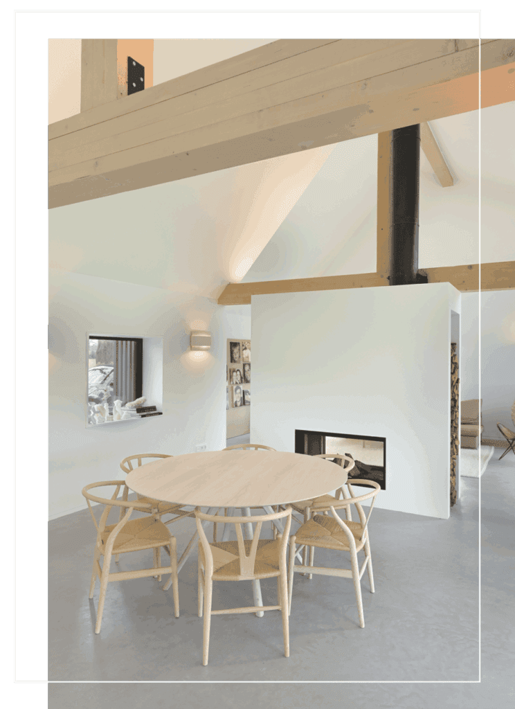 Lichte eethoek ronde tafel 6 stoelen met open haard, grote open ruimte met wit en houttinten
